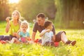 Happy family in the park together on a sunny day - children blow Royalty Free Stock Photo